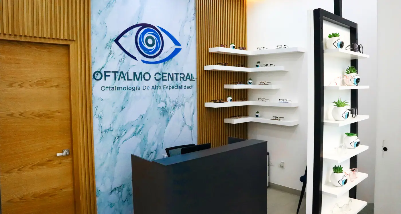 Interior de Oftalmo Central: recepción con muro de mármol y paneles de madera